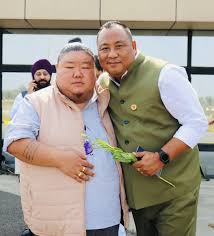 Benjamin Yepthomi photographed alongside a party colleague at an outdoor event.